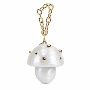 Close-up of pearl white mushroom evening bag with gold chain and studded details