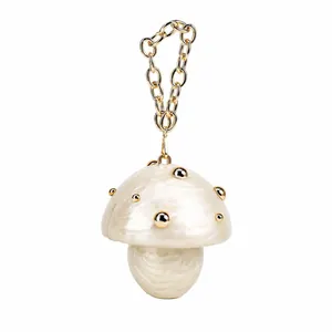 Detail of mushroom shaped acrylic evening bag with pearl texture and gold beads