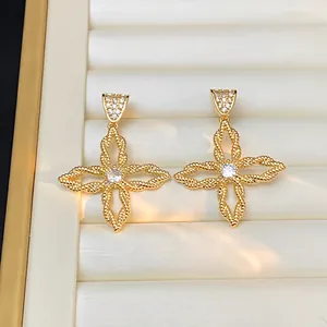 Detaillierte Nahaufnahme goldener Blumenohrringe mit runden Zirkonia in einer Box