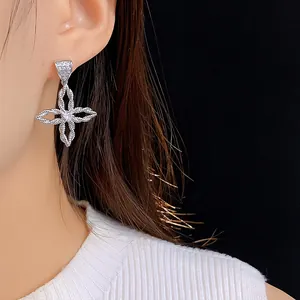Details von silbernen Blumen-Ohrhängern mit Zirkonia-Stein und Textur auf einem Modell