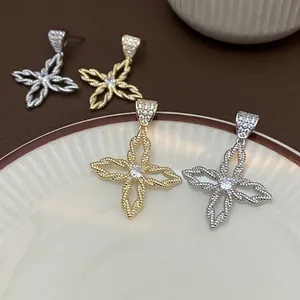 Detail von blumenförmigen Ohrringen mit Gold- und Silberplattierung und Zirkonia