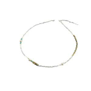 Collier chic avec perles blanches, entretoises turquoise et pierres naturelles sur blanc