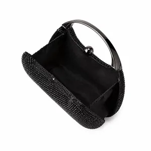 Close-up of black rhinestone evening clutch with polished metal handle and inner lining