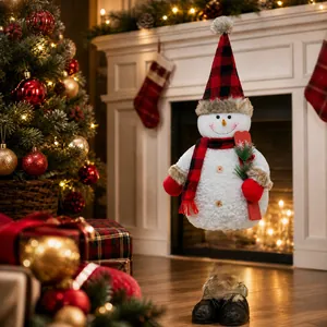 Detail of plush snowman ornament with red and black plaid hat by a cozy fireplace