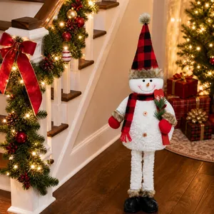 Detail of Christmas snowman figurine with red black plaid hat and pine needle accents