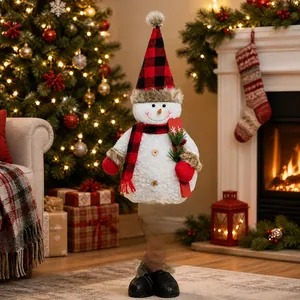 Detail of plush snowman with red and black plaid hat standing by a Christmas tree