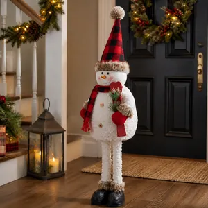Close-up of standing snowman with red-black plaid hat and scarf in home festive decor