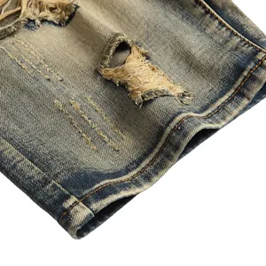Close-up of vintage blue washed denim shorts featuring heavy distressing and frayed holes