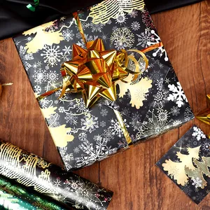 Christmas gift wrapping paper with reindeer and golden snowflake patterns and a bow