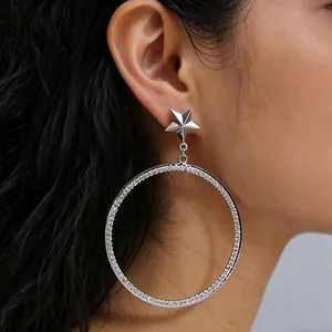 Chic silver star hoop earrings with sparkling pavé crystals worn by a model