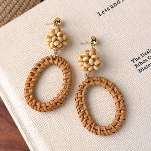 Details von handgefertigten Strohohrringen im Boho-Stil mit Rattan und Holzperlen