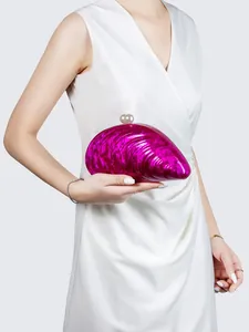 Detailansicht der fuchsiafarbenen Acryl-Clutch in Muschelform mit Marmormuster