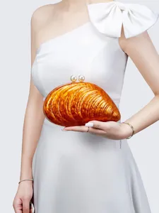 Detail einer orangefarbenen Muschel-Clutch aus Acryl mit großen Perlenverschlüssen für Hochzeiten