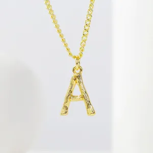 Detailed close-up of golden letter A pendant with bamboo texture on a fine chain