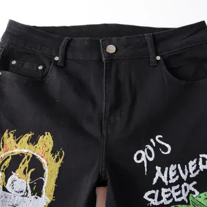 Men's black slim fit stretch jeans with 90's text and yellow flame skull graffiti prints