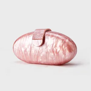 Detail of pink marble acrylic shell clutch bag with smooth texture and metal clasp