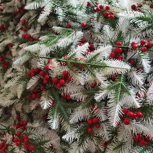 Primo piano di aghi di pino in PE con bacche rosse per decorazioni natalizie DIY