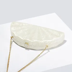 Detailed close-up of fan-shaped acrylic evening clutch with gold chain strap and marble finish
