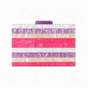 Détail d'une pochette de soirée rayée en acrylique nacré avec fermoir rectangulaire