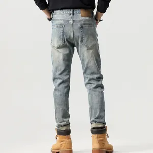 Jeans slim straight da uomo lavaggio azzurro con dettagli consumati e toppa