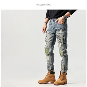 Jeans da uomo slim con toppe ricamate e lavaggio vintage azzurro con dettagli strappati