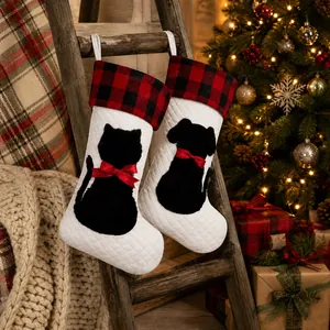 Detail of buffalo plaid Christmas stockings with black cat and dog motifs on a wooden ladder