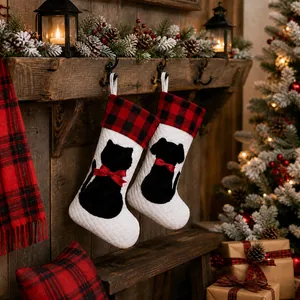 Detail of buffalo plaid Christmas stockings with black cat and dog silhouettes on fireplace