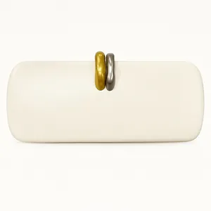 Close-up of artistic gold and silver organic metal clasp on cream PU clutch bag