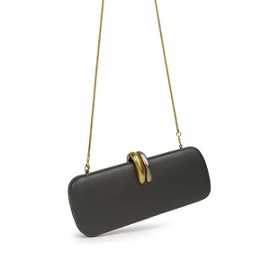 Close-up of a grey evening clutch with intertwined gold and silver metal ring buckle