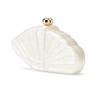 Détail d'une pochette en acrylique blanc marbré avec un fermoir à boule en métal doré chic