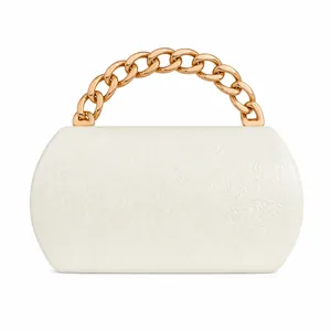 Detailed close-up of white embossed leather clutch with chunky gold chain handle