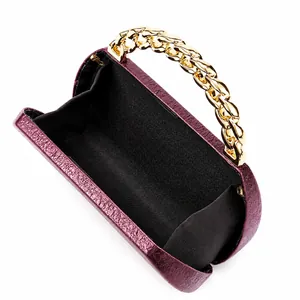 Macro view of dark purple textured leather handbag with thick gold metal chain strap