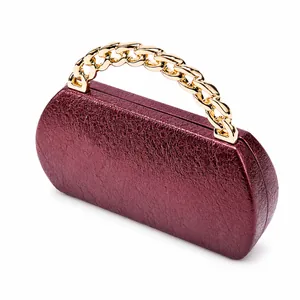 Detail of burgundy foil texture evening clutch with thick gold chain handle and hard shell