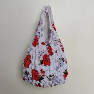 Detail of white bubble popcorn bag featuring red flowers and lilac floral print texture