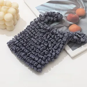 Detail shot of a dark grey bubble textured magic bag on a white aesthetic background