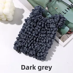 Detail of dark grey bubble textured bag with elastic pleats and minimalist design