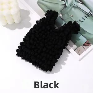 Detailed close-up of a black textured bubble bag with unique wave pleat fabric craftsmanship