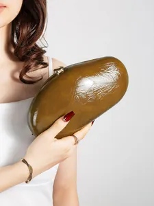Macro shot of olive green glossy patent leather clutch with silver cylinder clasp lock