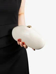 Detailed close-up of ivory pearl dinner clutch with feather texture and golden clasp