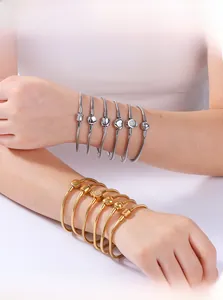 Detail of gold and silver snake chain bracelets with heart and crown clasp closures