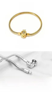 Detail of gold and silver snake chain bracelets with crown-decorated crystal clasps