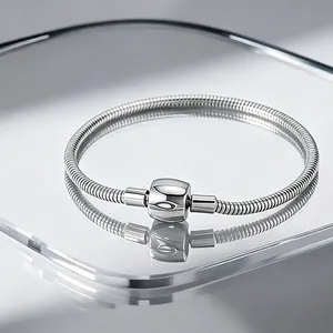 Classic silver stainless steel snake chain bracelet with barrel clasp on mirror surface