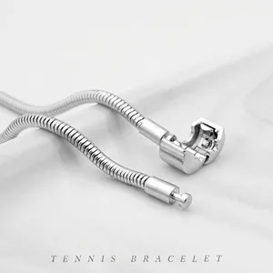 Classic silver stainless steel snake bone chain bracelet with spherical clasp on white fabric
