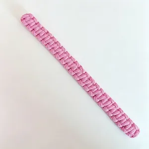 Close-up of pink handmade bohemian woven cotton curtain tieback with detailed texture