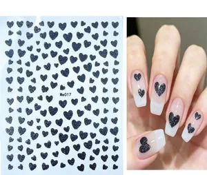 Detail of Me017 black glitter heart nail stickers with hand model application view