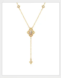 Detail of a gold Y-shaped necklace with retro hollow pattern and opal stone inlay