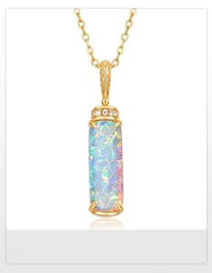 Macro shot of rectangular opal pendant with rainbow fire and gold engraved clasp