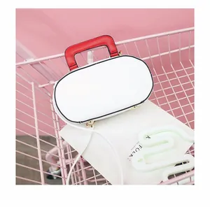 Top view of white retro radio shaped handbag with red handle in a pink cart