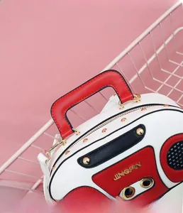 Detailed view of vintage radio shaped bag with gold studs and red top handle