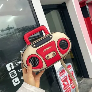 Detail of vintage radio shape handbag with gold chain strap and speaker grille design